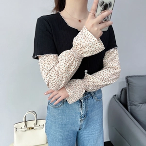 Detail view of floral chiffon flare sleeves with elastic cuffs on a black knit top