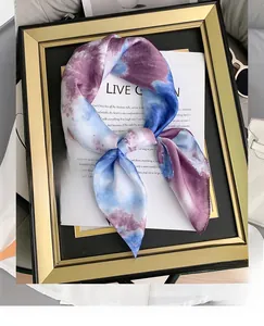 Artistic tie-dye silk scarf in purple and blue styled with sunglasses and leather bag