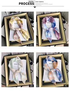 Detail view of silk-feel scarves in four gradient colors displayed in golden frames