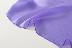 Close-up of purple gradient silk scarf fabric showing fine texture and hemmed edges