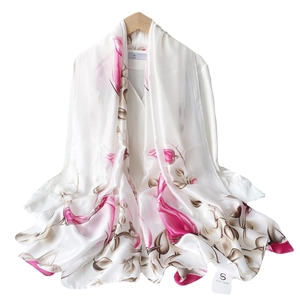 Elegant white silk scarf with pink magnolia flower prints on a white shirt and hanger