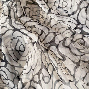 Detailed macro view of black and white camellia floral pattern on sheer chiffon silk scarf