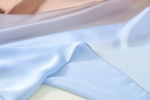 Macro shot of gradient satin silk scarf showing smooth texture and fine stitching detail