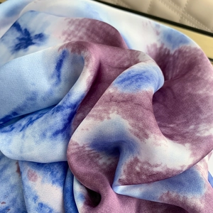 Close-up of blue and purple tie-dye silk scarf showing smooth texture and drape