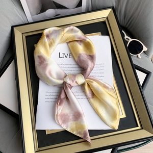 Elegant silk-feel tie-dye scarf in yellow and purple tied in a bow within a gold frame