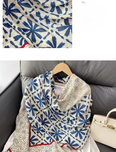 Detailed view of floral print scarf with geometric borders and lightweight texture