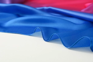 Close-up of royal blue gradient silk scarf showing premium glossy texture and hem stitch