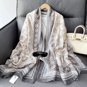 Detailed texture of bohemian linen-feel scarf with geometric prints over white shirt