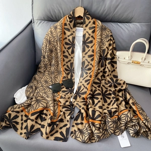 Scarf with geometric prints and floral patterns styled over a white shirt and sofa
