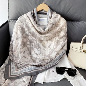 Detail of bohemian geometric print scarf displayed on a wooden hanger with accessories