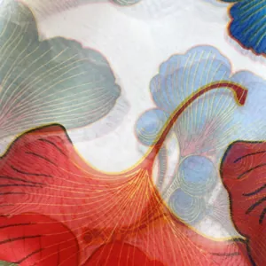 Détail macro d'un foulard en soie montrant des motifs de ginkgo et une texture de tissu fine