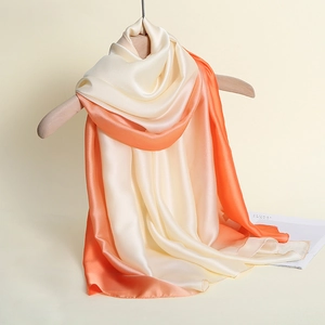 Detail of silk scarf with gradient champagne to coral orange transition and silk luster