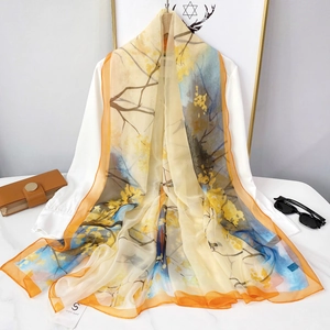 Gros plan d'une écharpe en soie imprimée légère drapée sur une chemise blanche chic