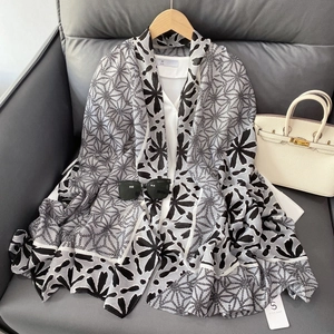 Detail view of geometric floral print scarf in black and white styled with a handbag