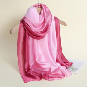 Detail of gradient silk scarf showing smooth satin texture and elegant pink ombre transition