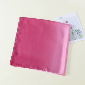 Detailed view of pink gradient silk scarf with smooth satin texture and elegant finish
