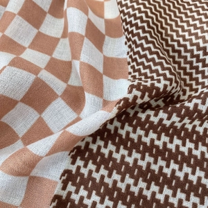 Close-up of houndstooth and checkered patterns on soft cotton-linen beach scarf