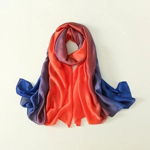 Detail showing smooth gradient transition from deep blue to vibrant orange on satin scarf