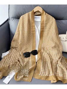 Detail of a thick ginger linen scarf with white geometric square patterns on a white shirt