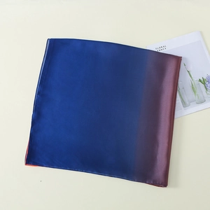 Detail of silk satin gradient scarf with smooth blue to orange transition and fine texture