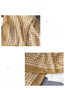 Detailed view of the brown and white houndstooth pattern and refined rolled edges of scarf