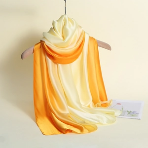 Detail showing the soft gradient texture and silk fabric of the yellow-orange scarf