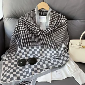 Detailed shot of houndstooth and checkered linen scarf hanging on a wooden hanger