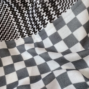 Detailed close-up of houndstooth and checkerboard patterns on a woven cotton linen scarf