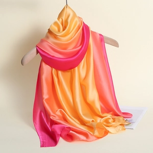 Detailed view of long silk scarf with gradient golden orange to deep pink transition