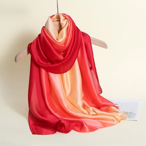 Detail shot of the red to orange gradient silk scarf with a smooth satin finish