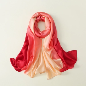 Detail of gradient silk scarf showing smooth transition from red to peach and cream