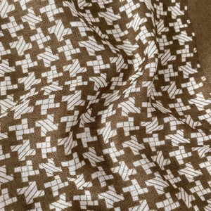 Macro detail of brown and white checkered star pattern woven scarf with soft fabric texture