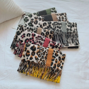 Close-up of leopard print scarves in multiple colors with fine fringe detail on fabric