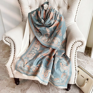 Dettaglio dello scialle paisley blu e arancione con trama fine del tessuto e frange
