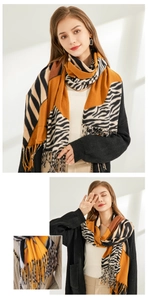 Détail du châle en tricot avec motif zébré orange et noir et élégantes longues franges