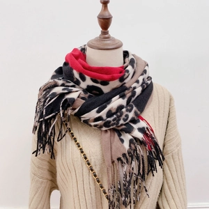 Close-up of leopard print scarf featuring long fringes and soft cashmere-like texture