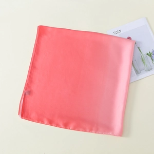 Detail of pink satin scarf showing smooth texture and high-quality stitched edges