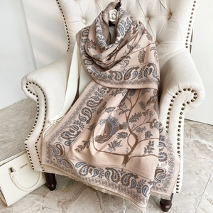 Dettaglio del motivo paisley e uccelli su sciarpa rosa effetto cashmere su sedia