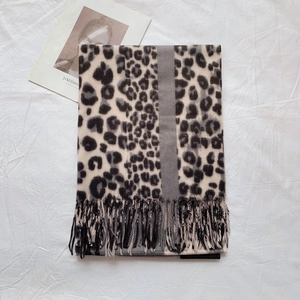 Close-up of leopard print scarf with gray stripe detail and fringed edges for autumn