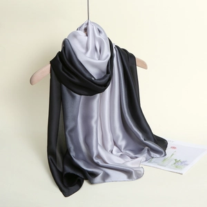 Detail view of long gradient satin scarf in black, grey and white on a wooden hanger
