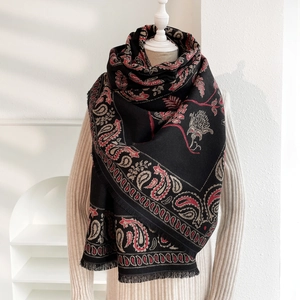 Dettaglio di sciarpa invernale in cashmere con frange calde e motivi paisley fini