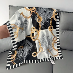 Detail of elegant cotton linen scarf with luxury gold chain and baroque floral print