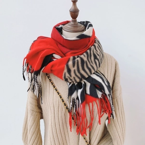 Détail de l'écharpe en cachemire synthétique à motif zébré avec des accents rouges et franges