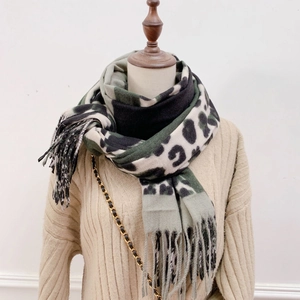 Close-up detail of leopard print scarf with soft fringe edges and warm texture