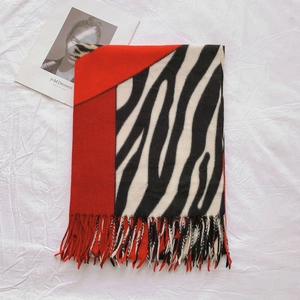 Détail d'une écharpe à motif zébré avec des franges rouges et texture épaisse
