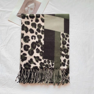 Detail of leopard print scarf with geometric color blocks and fringe tassels