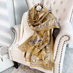 Dettaglio di motivo paisley e uccelli su scialle con frange in finto cashmere giallo