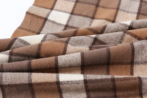 Detailed close-up of brown plaid scarf fabric showing soft brushed texture and twill weave