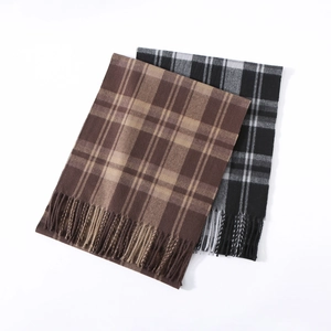 Detailed view of plaid scarves in brown and black-grey colors with soft fringe tassels