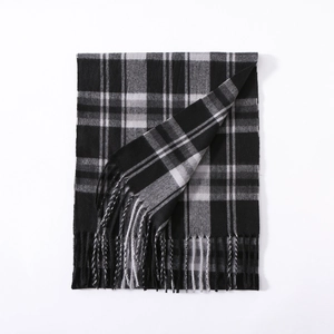 Detailed view of grey plaid scarf with soft tassels and warm knit texture for winter